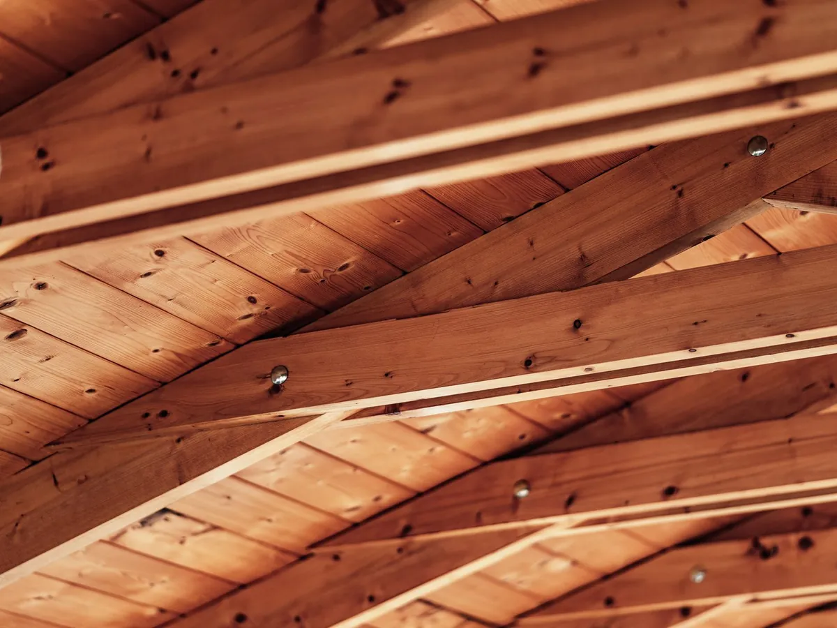 Chevrons en bois sous les rampants d'une toiture, avant isolation