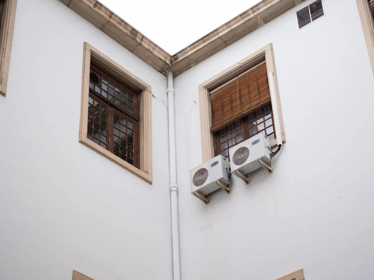 Deux unités extérieures de climatisation fixées sur une façade enduite