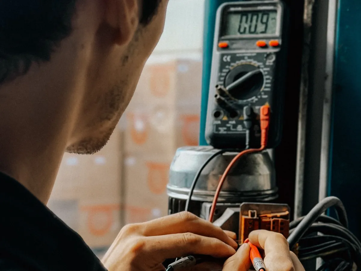 Électricien qui mesure une installation avec un multimètre