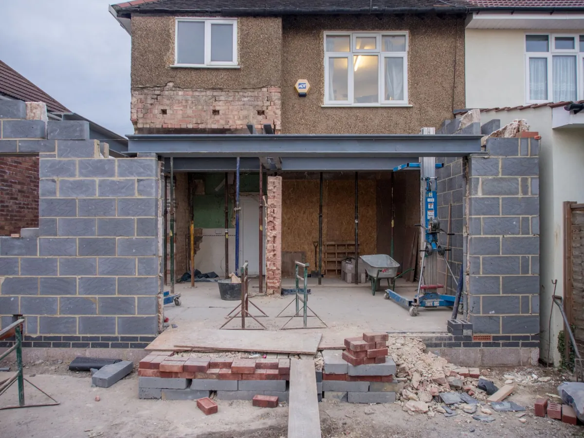 Extension en parpaings en construction à l'arrière d'une maison en briques