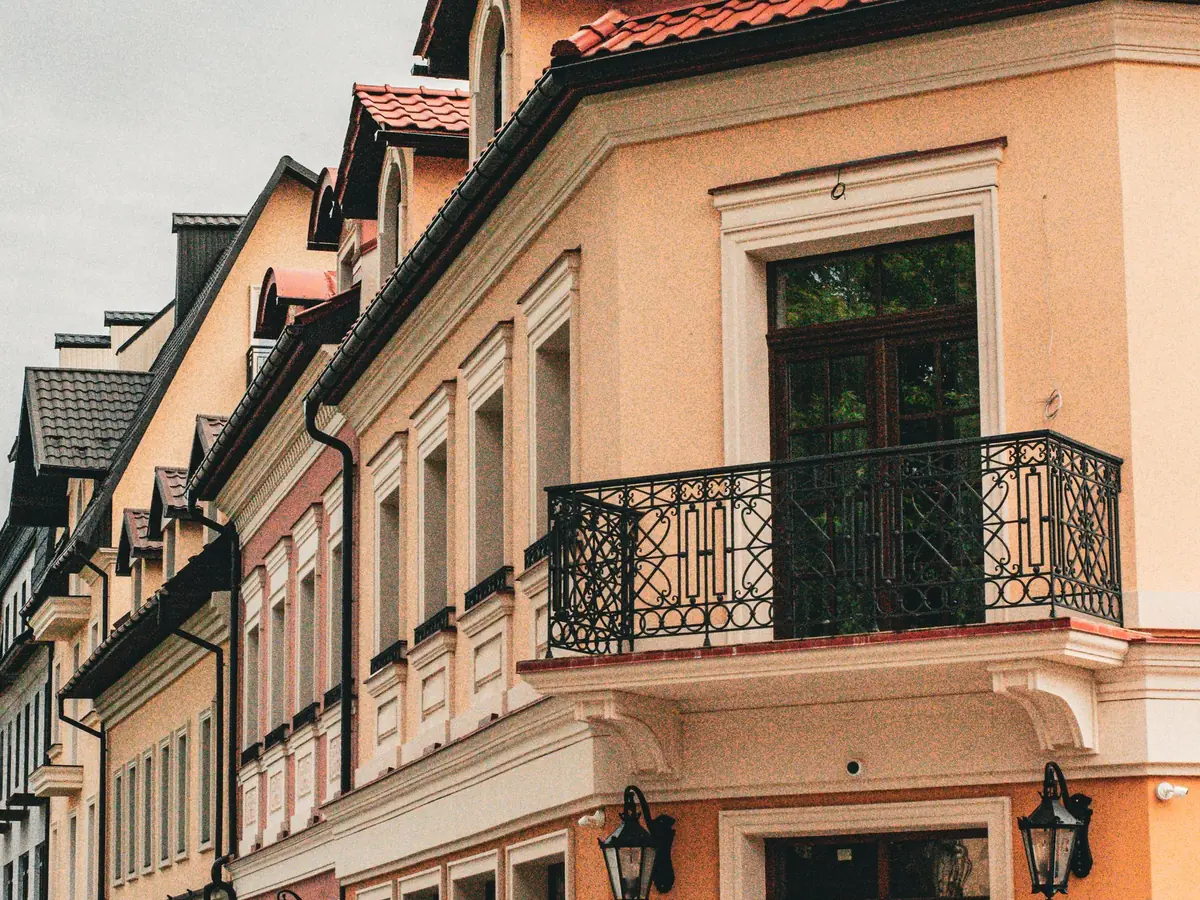 Façade de maison enduite avec balcon en fer forgé