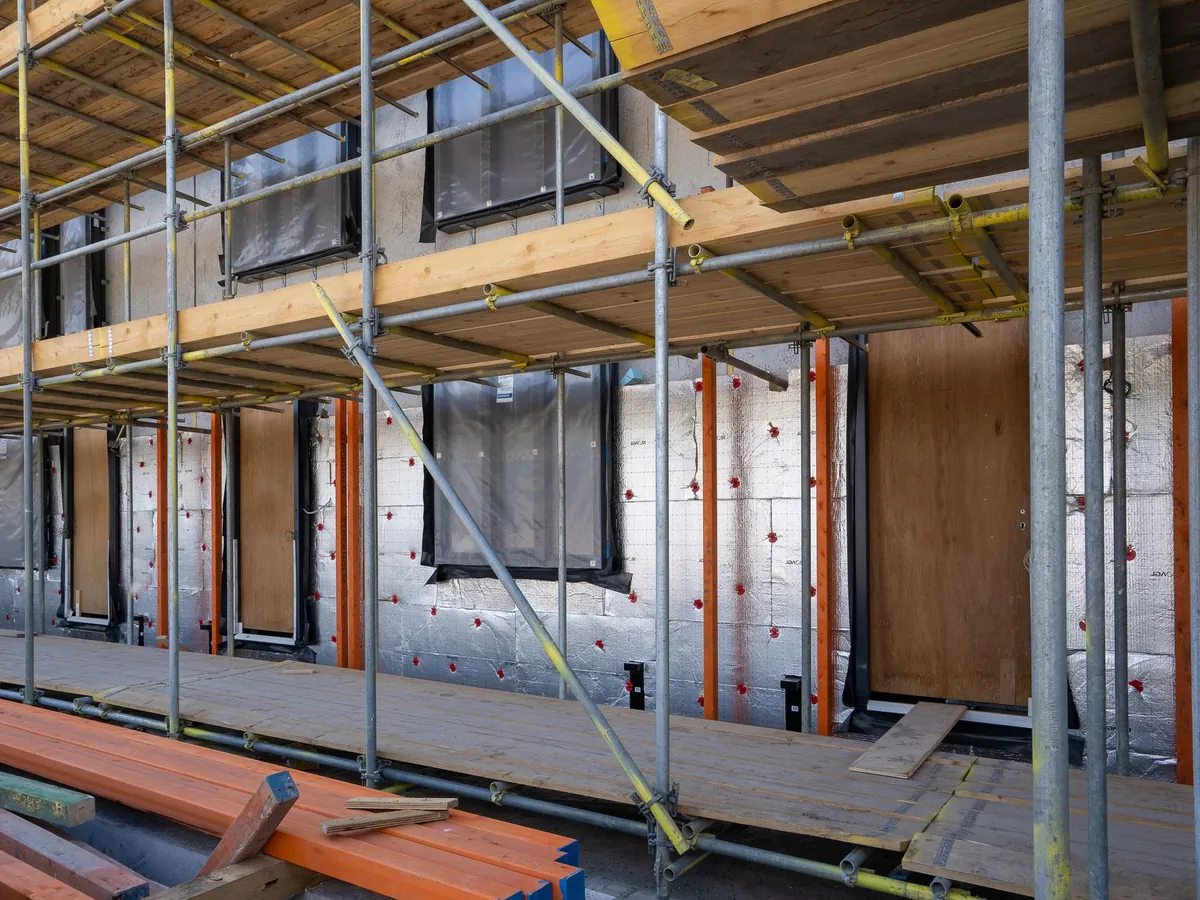 Façade en cours d'isolation par l'extérieur derrière un échafaudage