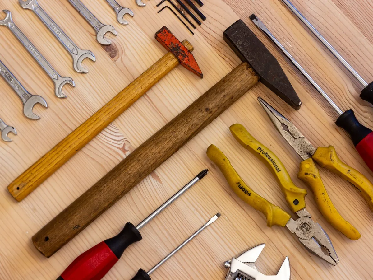 Outils de bricolage posés sur un établi : marteau, pinces, clés et tournevis