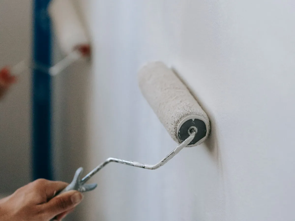 Rouleau de peinture sur un mur blanc