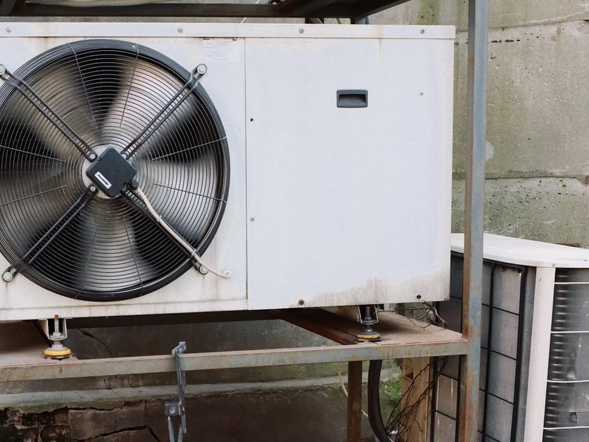 Unité extérieure de pompe à chaleur avec son ventilateur, posée sur un support