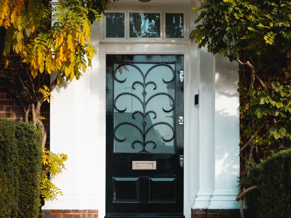 Porte d'entrée noire avec vitrage et ferronnerie décorative