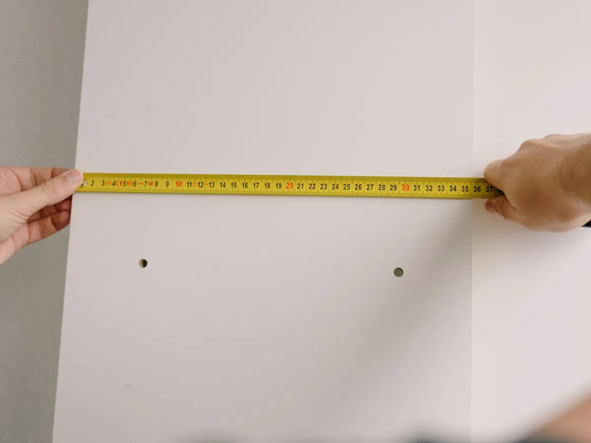 Mètre ruban tendu sur un mur pour placer une étagère