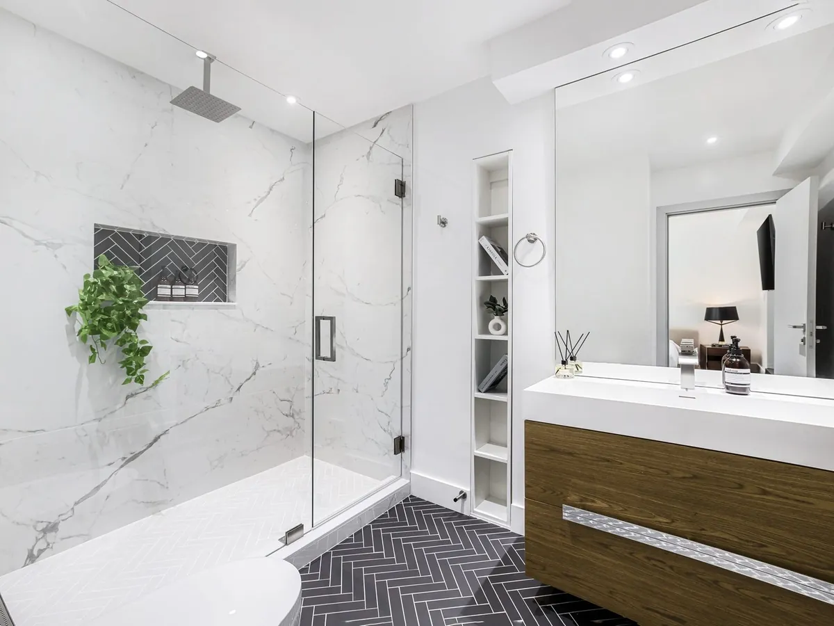 Salle de bain rénovée avec douche vitrée et meuble vasque en bois