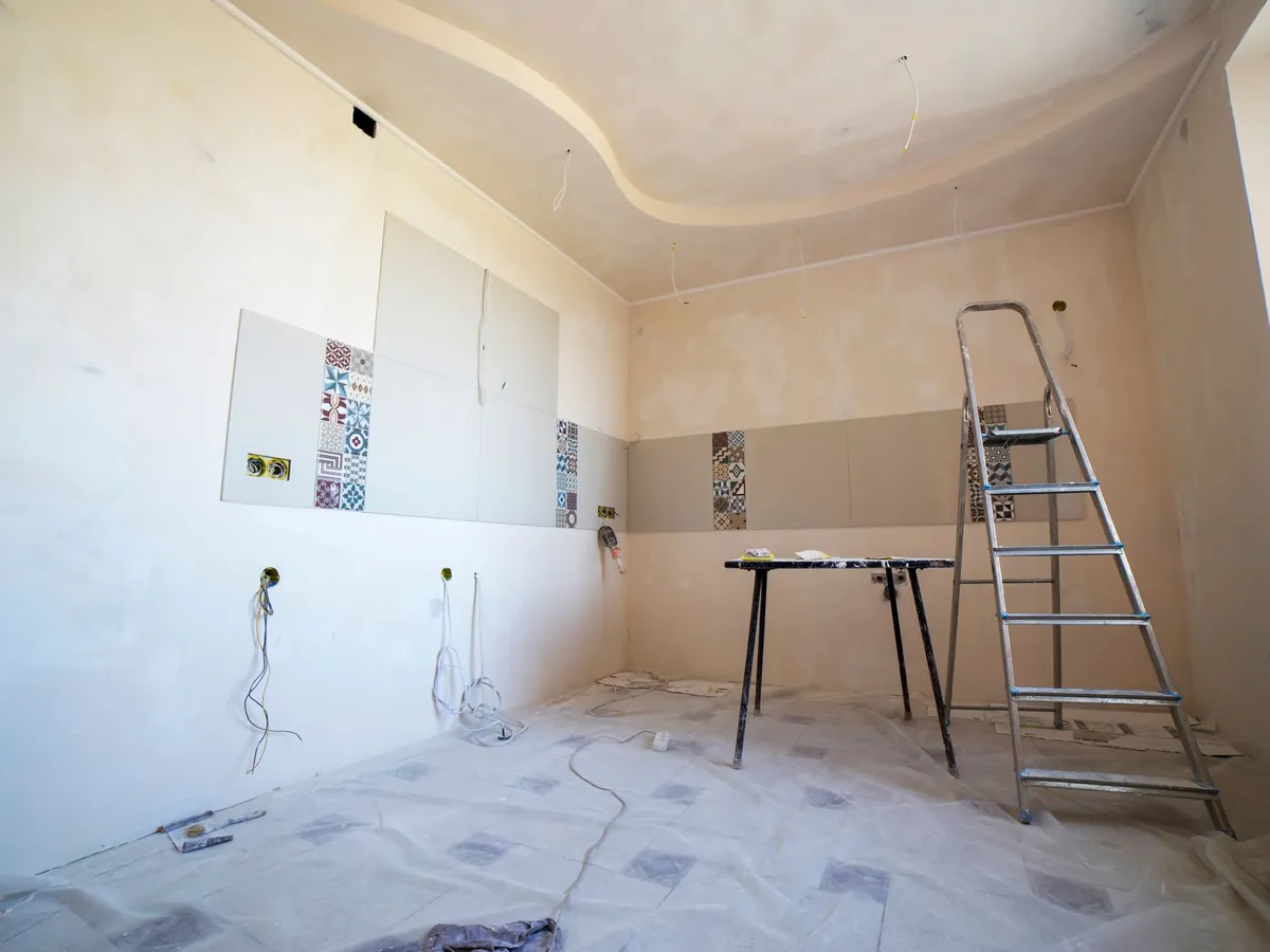 Salle de bain en cours de rénovation, murs préparés et escabeau