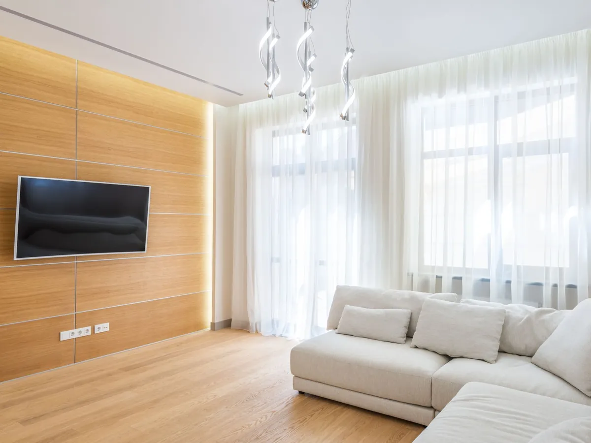 Télévision fixée au mur d'un salon lumineux